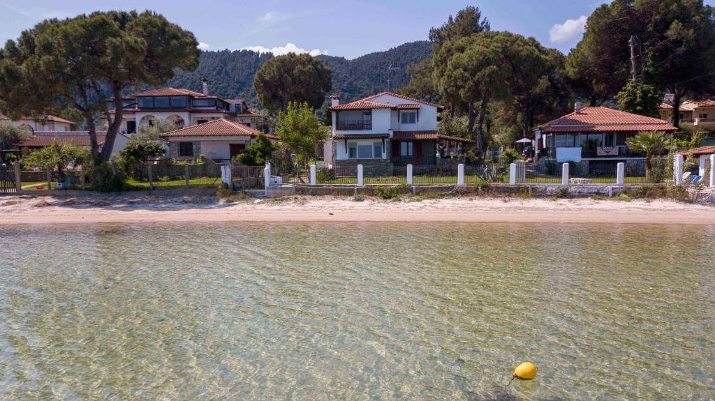 a yellow ball in the water in front of houses at Docker 2 Beachfront Villa Vourvourou by Halkidiki Villas in Vourvourou