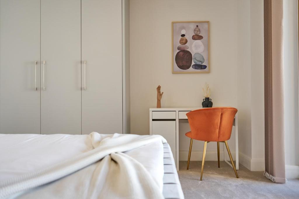 - une chambre avec un lit, une chaise et un bureau dans l'établissement Luxury Stylish 2 Beds / 2 Baths, à Londres