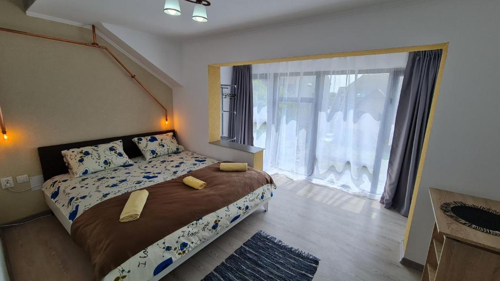 een slaapkamer met een bed en een groot raam bij Pomiculturii Residence 7 in Timişoara