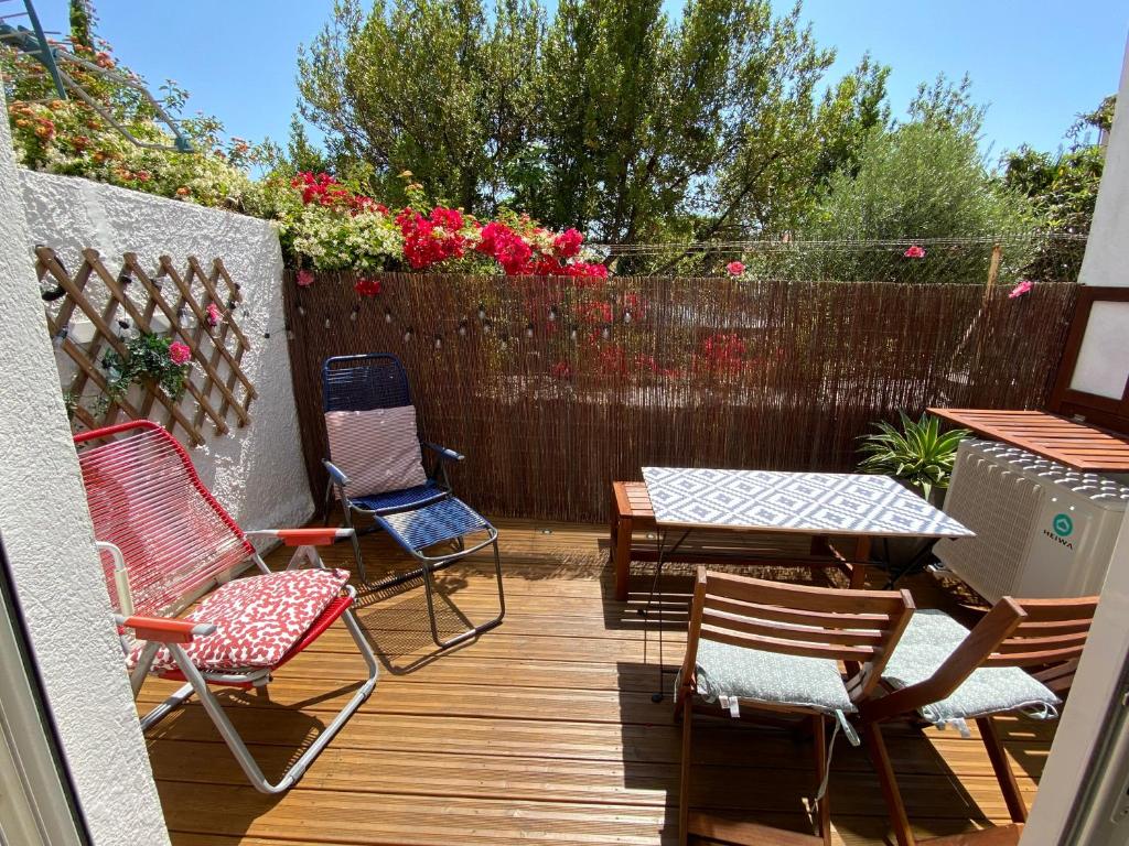 een patio met stoelen en tafels en een hek bij DOUCEUR BANDOLAISE in Bandol