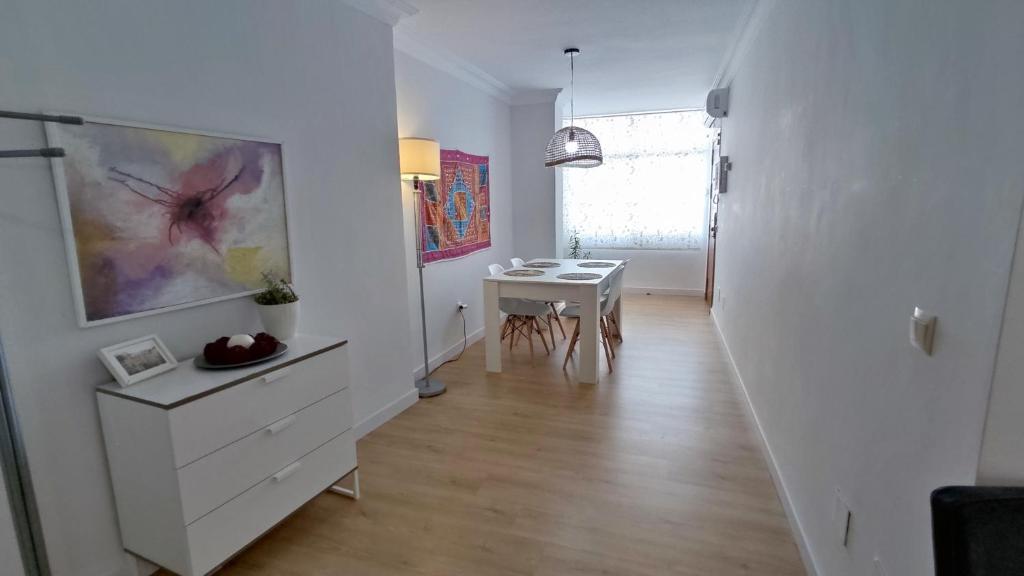 ein weißes Zimmer mit einem Tisch und einer weißen Kommode in der Unterkunft Céntrico Apartamento en Ronda in Ronda