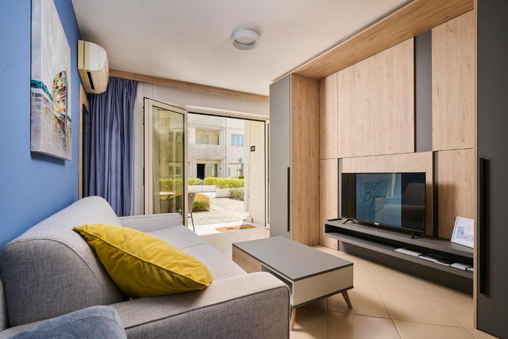 a living room with a couch and a tv at Supreme Studio Apartment Bijoux in Umag