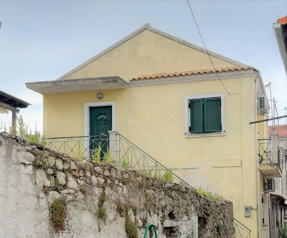 a house with a green door on a stone wall at RIVER SIDE HOUSE in Potámion