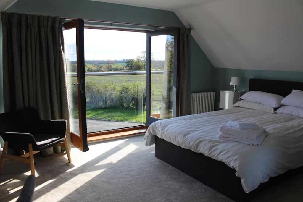 1 dormitorio con cama y ventana grande en Boutique double room with country village views en Wilby