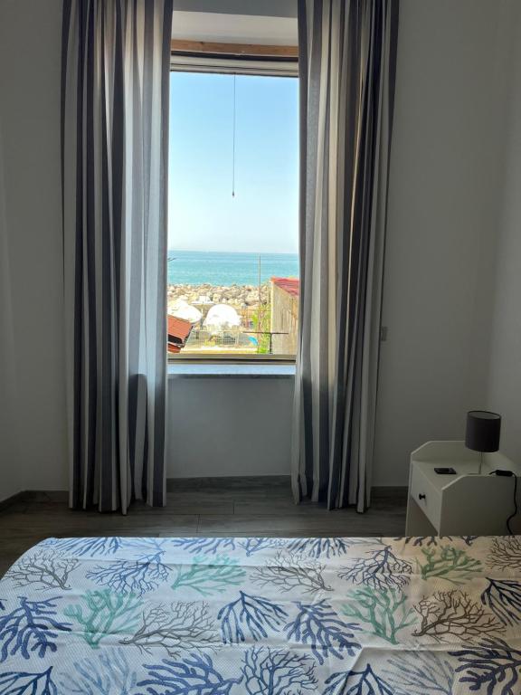 a bedroom with a bed and a large window at Elvis Home in Salerno