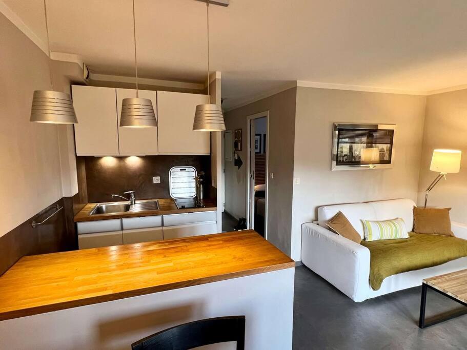eine Küche und ein Wohnzimmer mit einer weißen Couch in einem Zimmer in der Unterkunft appartement la Croix Valmer in La Croix-Valmer