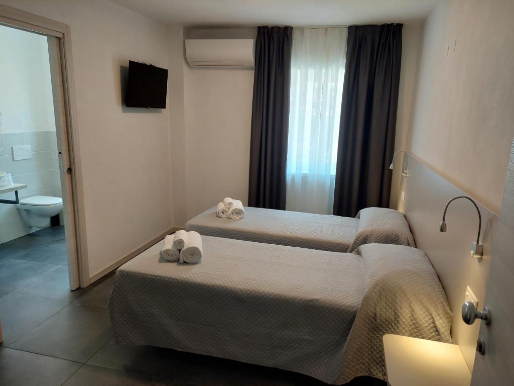 a hotel room with two beds and a mirror at IL VITIGNO in Dossobuono