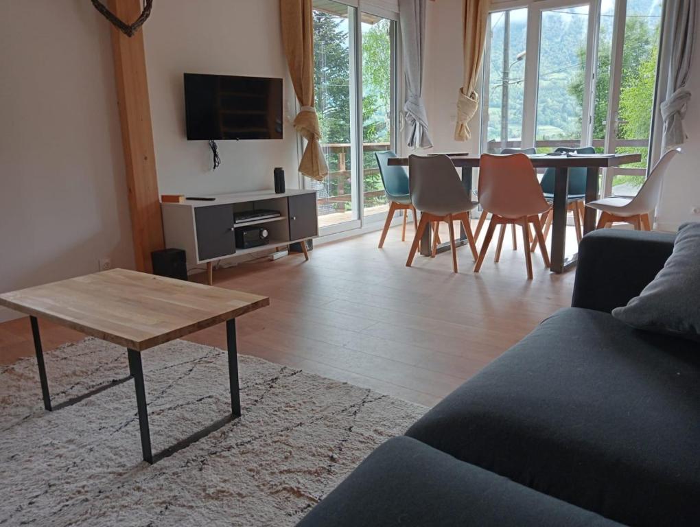 sala de estar con sofá, mesa y sillas en Châlet montagne 6 personnes, en Laruns
