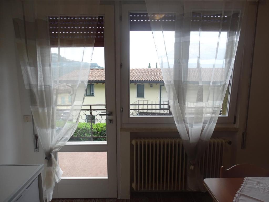 an open door with curtains and a view of a building at Casa Marica - Appartamento nel Borgo di Pieve in Tremosine Sul Garda