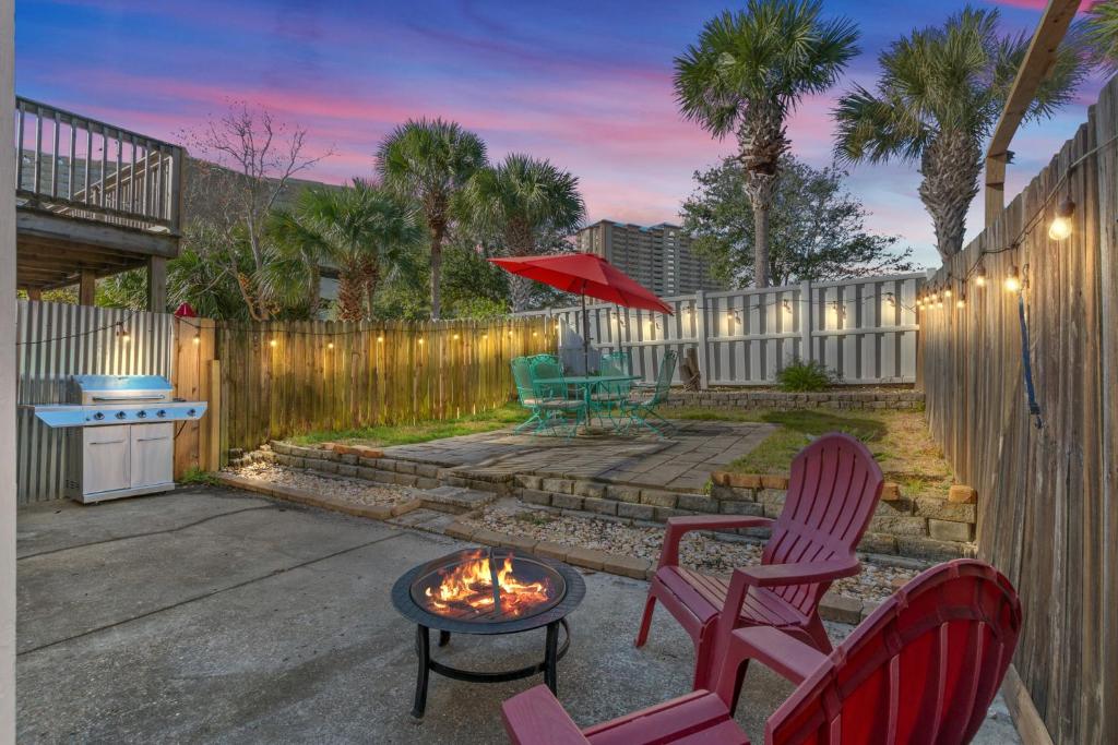 a patio with two chairs and a fire pit at Beach Haven - Seasonal Hot Tub, Fire Pit, BBQ, 700 Feet to Beach, Central PCB, FREE Daily Activities, & More! in Panama City Beach