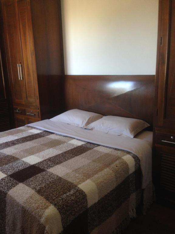 um quarto com uma cama com um cobertor xadrez em Aconchego 2 - Suíte em Varginha