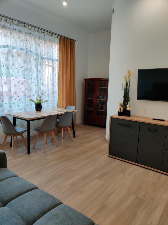 a living room with a table and a tv at apartament 2 pokoje in Kamień Pomorski