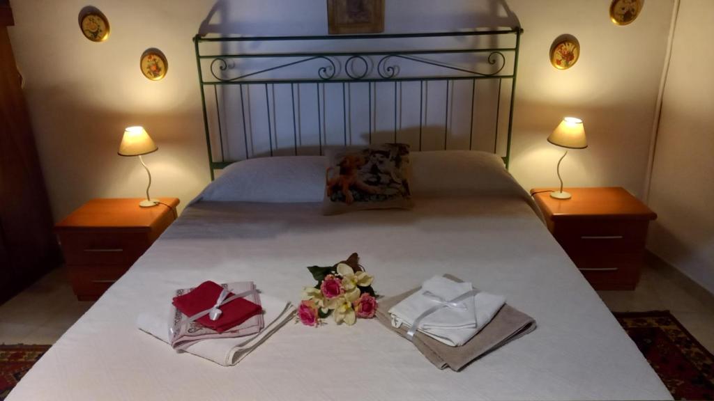 a bed with two towels and flowers on it at La Dimora del 1700 in Tivoli