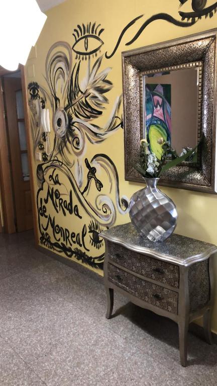 un jarrón sentado en una mesa frente a un espejo en La Mirada de Monreal, en Monreal del Campo