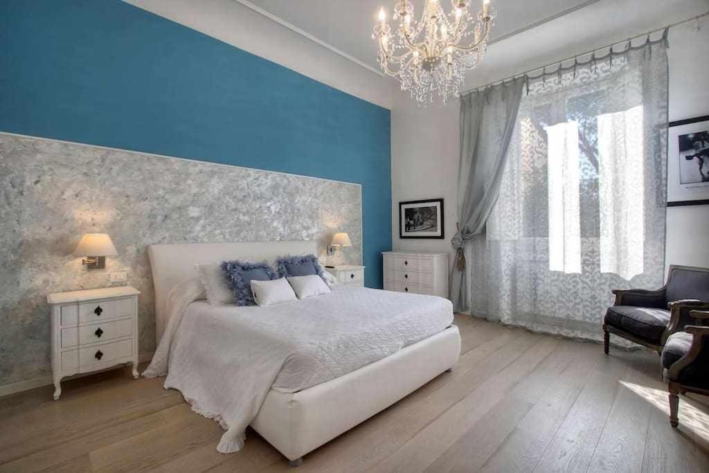 een slaapkamer met een groot bed en een kroonluchter bij San marco elegant apartment in Florence