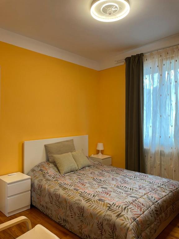 sypialnia z łóżkiem z żółtymi ścianami i oknem w obiekcie Habitaciónes Privadas en Hendaye "Daniela", à 5 minutes de la gare d'Hendaye et Euskotren, Wi-Fi w mieście Hendaye