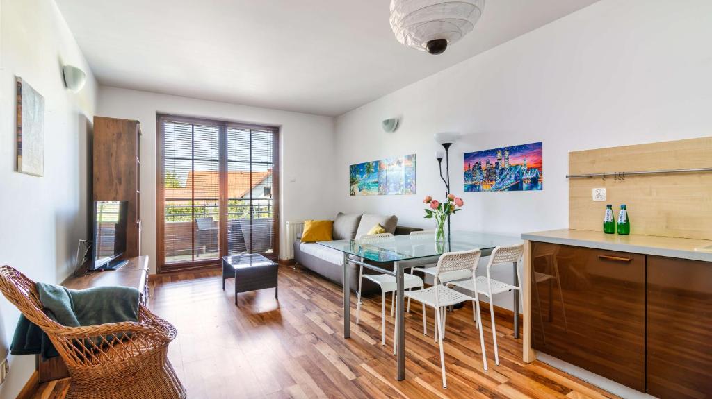 a kitchen and living room with a table and chairs at Apartamenty PIAMOLA Willa Turkusowa in Kąty Rybackie