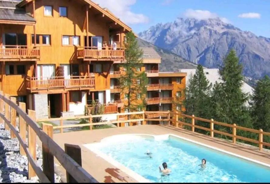 a large swimming pool in front of a hotel at Le hameau des écrins in Narreyroux