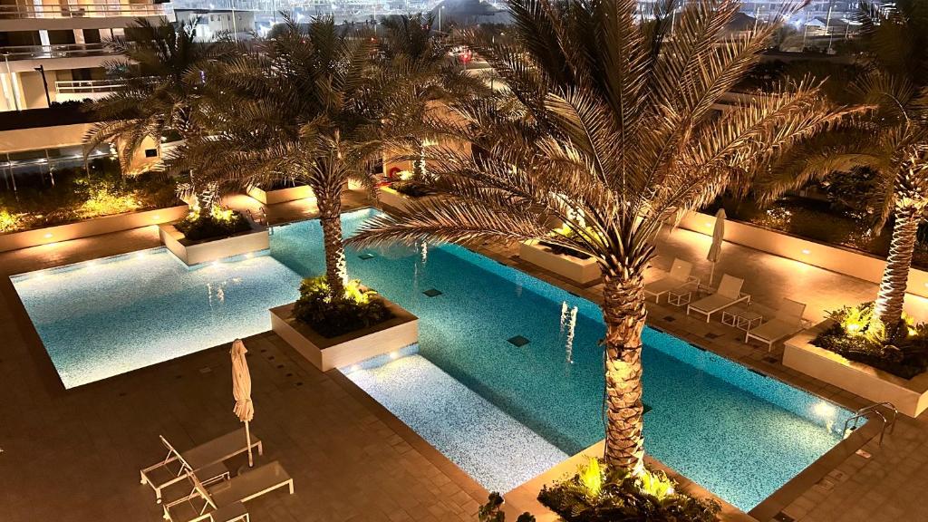 an overhead view of a swimming pool with palm trees at Charming 1-Bed Loft with Serene Pool View, Steps from the Beach in Abu Dhabi