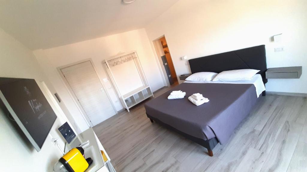 サンタ・テレーザ・ガッルーラにあるMaison Margheritaのベッドルーム1室(ベッド1台、白いタオル2枚付)