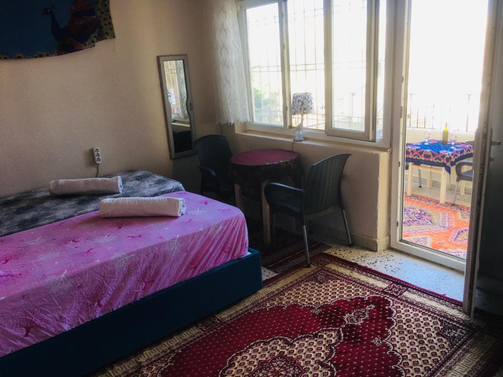 a bedroom with a bed and a table and a window at Rosa Hostel in Mardin