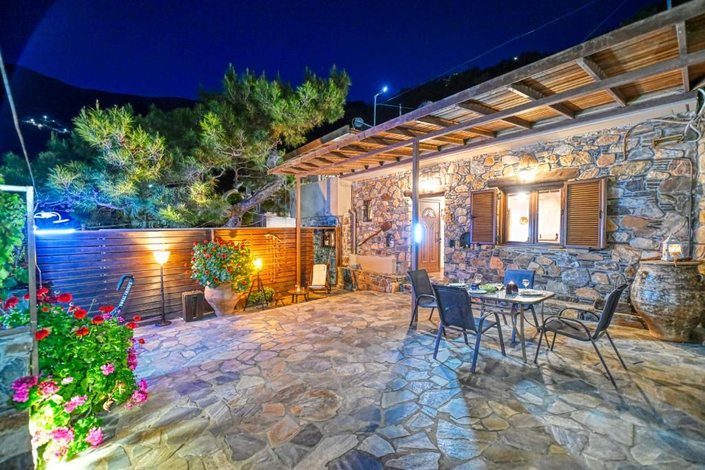 eine Terrasse mit einem Tisch und Stühlen vor einem Gebäude in der Unterkunft "PefkoPetro" Traditional House in Keramotí