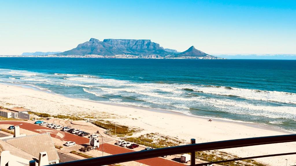 a view of a beach with a mountain in the distance at Portico 1006 Beachfront Apartment with Panoramic Views in Cape Town