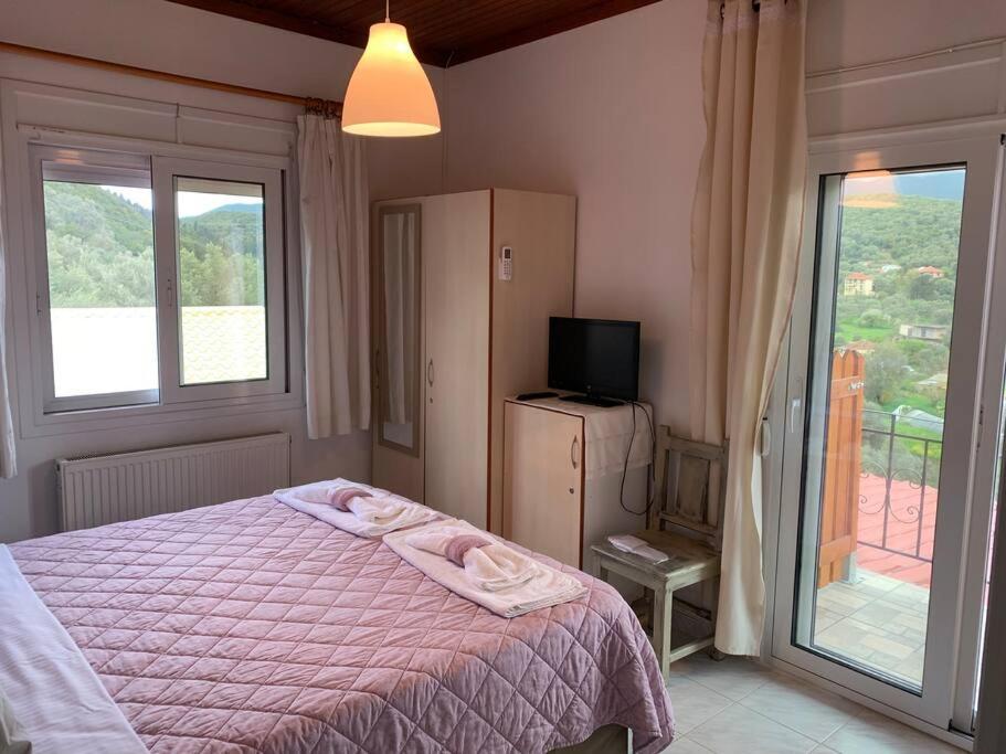 a bedroom with a bed and a balcony with a television at KONTI VILLA in Kondáraina