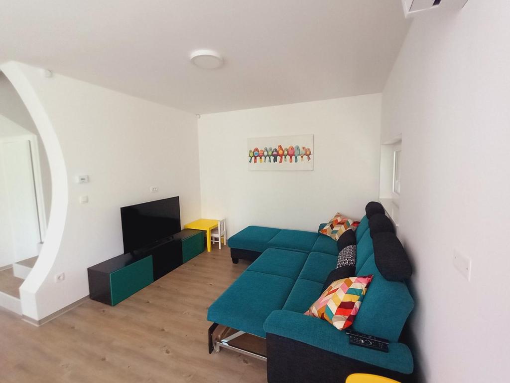 uma sala de estar com um sofá e uma televisão em Riverside Holiday House em Catez ob Savi