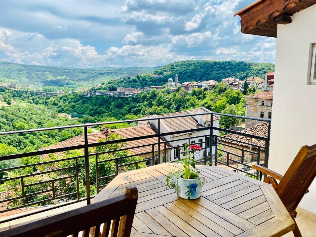 a wooden table on a balcony with a view at Tsarevets panoramic apartments Veliko Tarnovo in Veliko Tŭrnovo