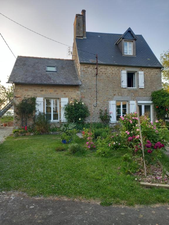 een stenen huis met een tuin met bloemen bij La châtre in Ronthon