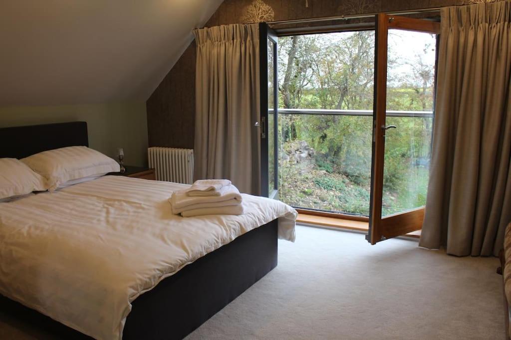 a bedroom with a bed and a large window at Boutique double room with countryside views in Wilby