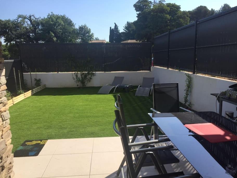 une terrasse avec des chaises et une pelouse avec une clôture. dans l'établissement T2 jardin à deux pas de la mer, à Saint-Cyr-sur-Mer