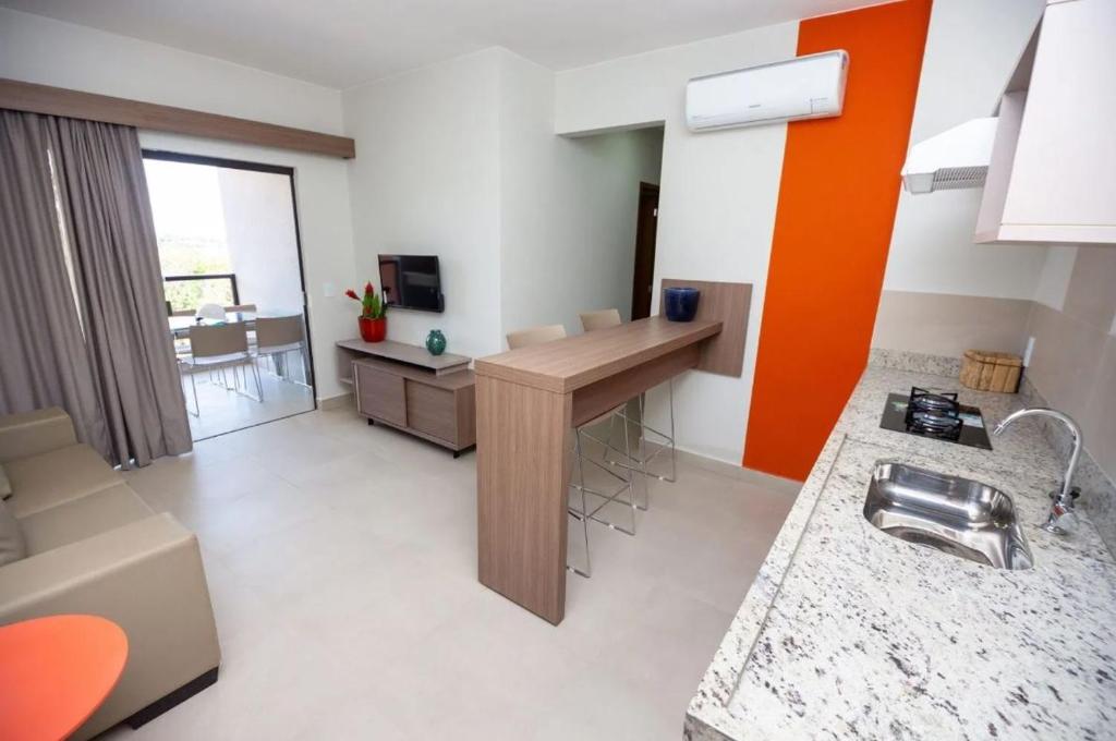 a room with a kitchen with a sink and a desk at Apartamento 2 quartos Lazer Completo in Caldas Novas