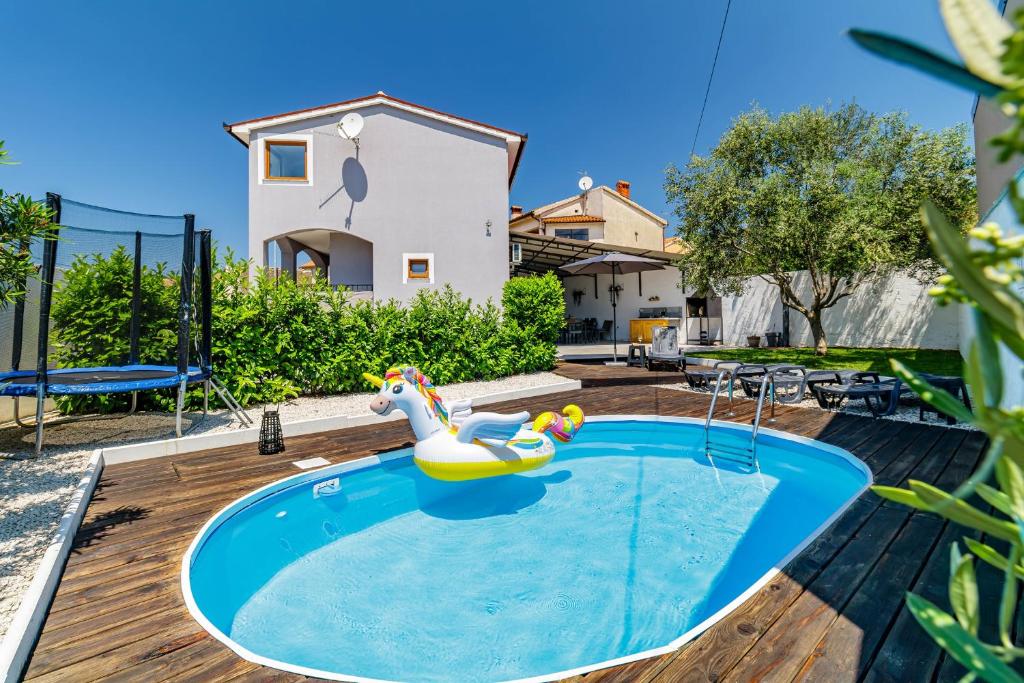 a swimming pool with a rubber duck in a backyard at Holiday House Ulika in Marčana