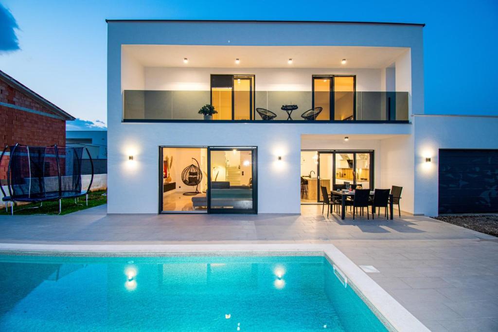 ein Haus mit einem Swimmingpool vor einem Haus in der Unterkunft Villa Mina with a private pool in Pula in Pula