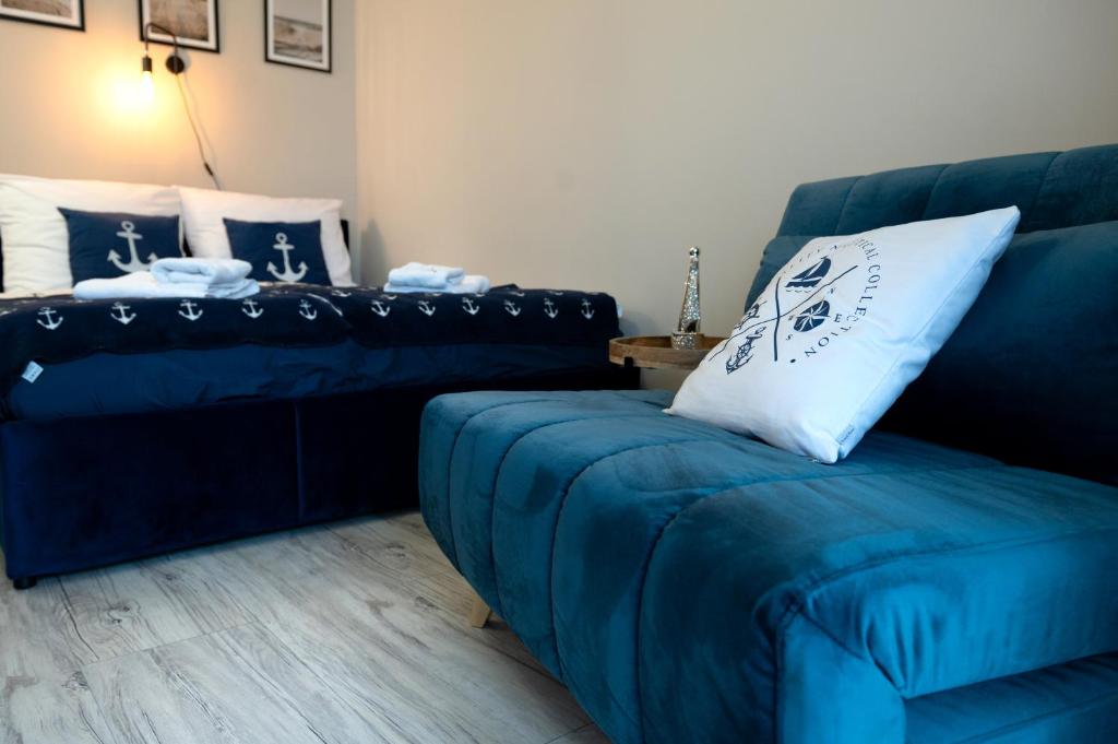 a living room with a blue couch and a chair at Blue Baltic & SPA in Dziwnów