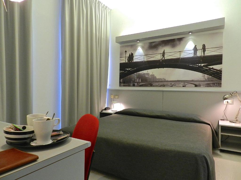 a bedroom with a bed with a picture of a bridge at Hotel Italia in Stradella