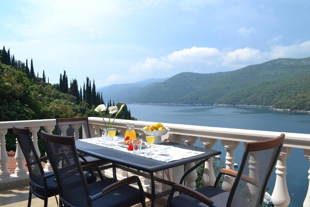 uma mesa numa varanda com vista para um lago em Apartment Jelena em Molunat