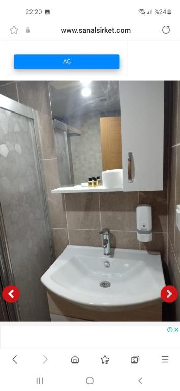 y baño con lavabo blanco y espejo. en Kınay pansiyon, en Belek