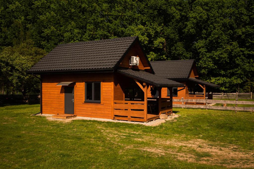 małą drewnianą kabinę z czarnym dachem w obiekcie Groszkówka 2 w mieście Narewka