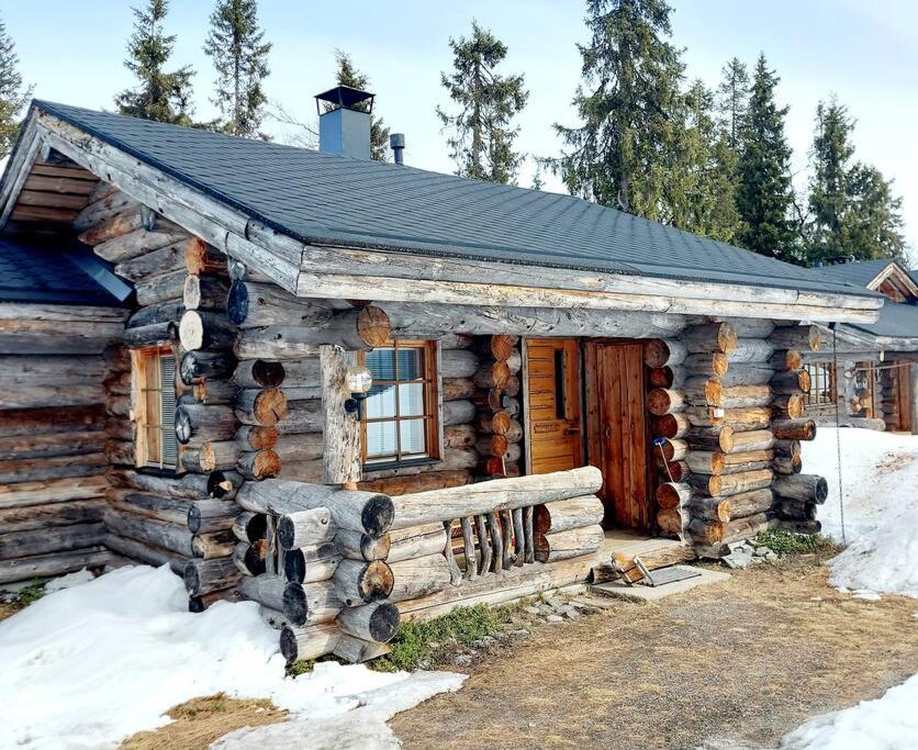 uma cabana de madeira na neve com uma janela em Ruka Monokolo, log apartment in Eastern Ruka em Kuusamo