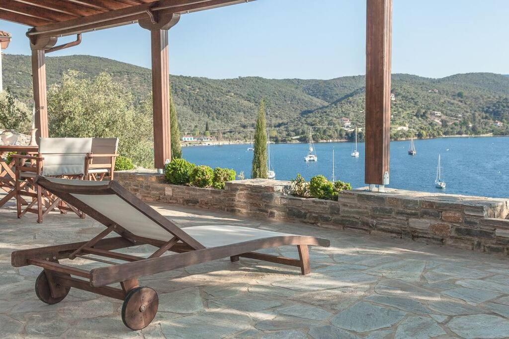 mecedora de madera en un patio con vistas al agua en Christy's House Sea View, en Agios Andreas
