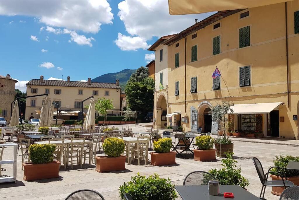 a patio with tables and chairs and a building at La casa Maestri a Cetona in Cetona