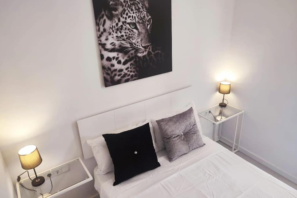 1 dormitorio con 1 cama y una foto de un leopardo en Des Artistes Lloret de Mar en Lloret de Mar