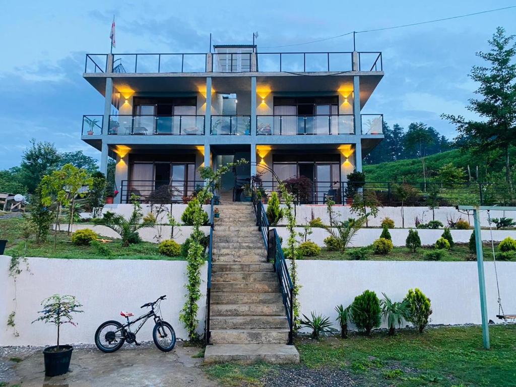 a bike parked in front of a house at Family Hotel Sunset in Chakvi