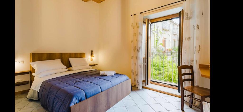 um quarto com uma cama e uma grande janela em Residenza Matilde em Fiumefreddo Bruzio