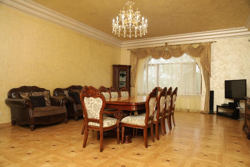 a dining room with a table and chairs and a television at Eriks guest house in Goris