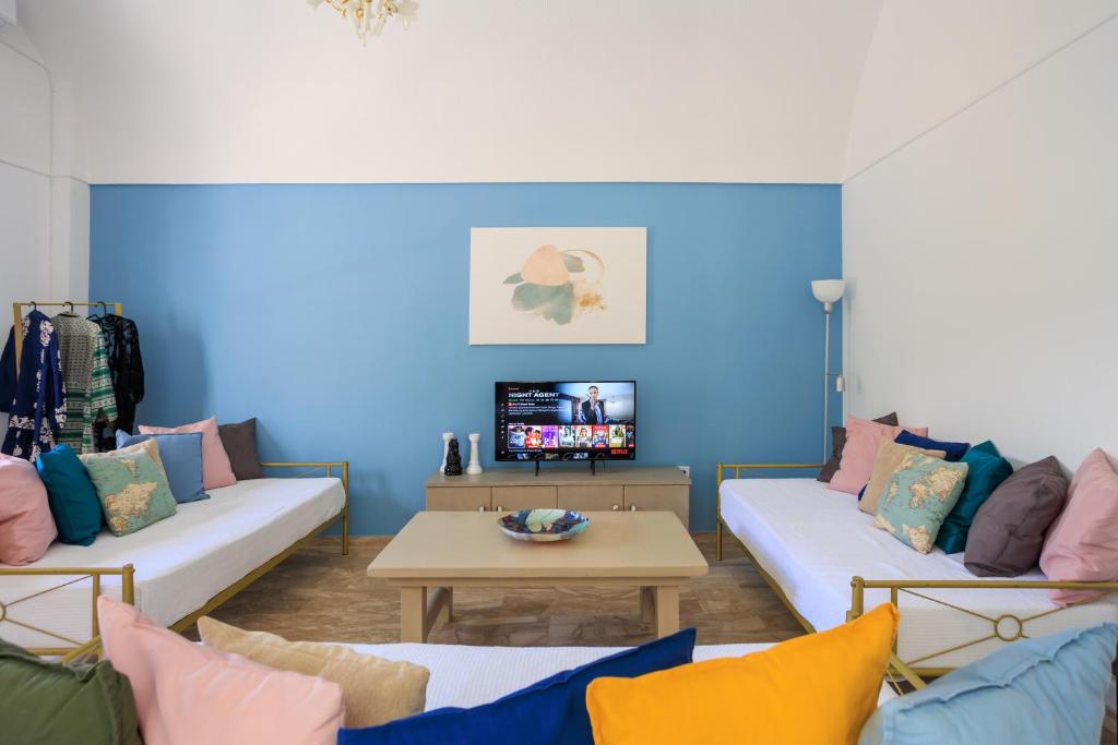 uma sala de estar com dois sofás e uma mesa em Aerno Home & Azul Ηοme - Ahilli Slow Living em Kamari