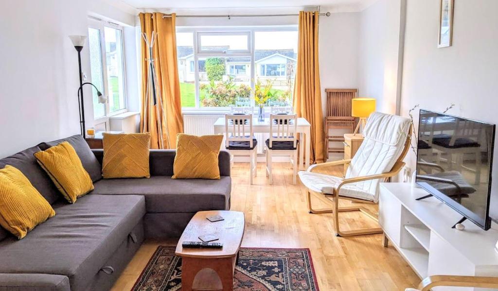 sala de estar con sofá y mesa en Comfortable bungalow near Widemouth Bay beach, en Poundstock